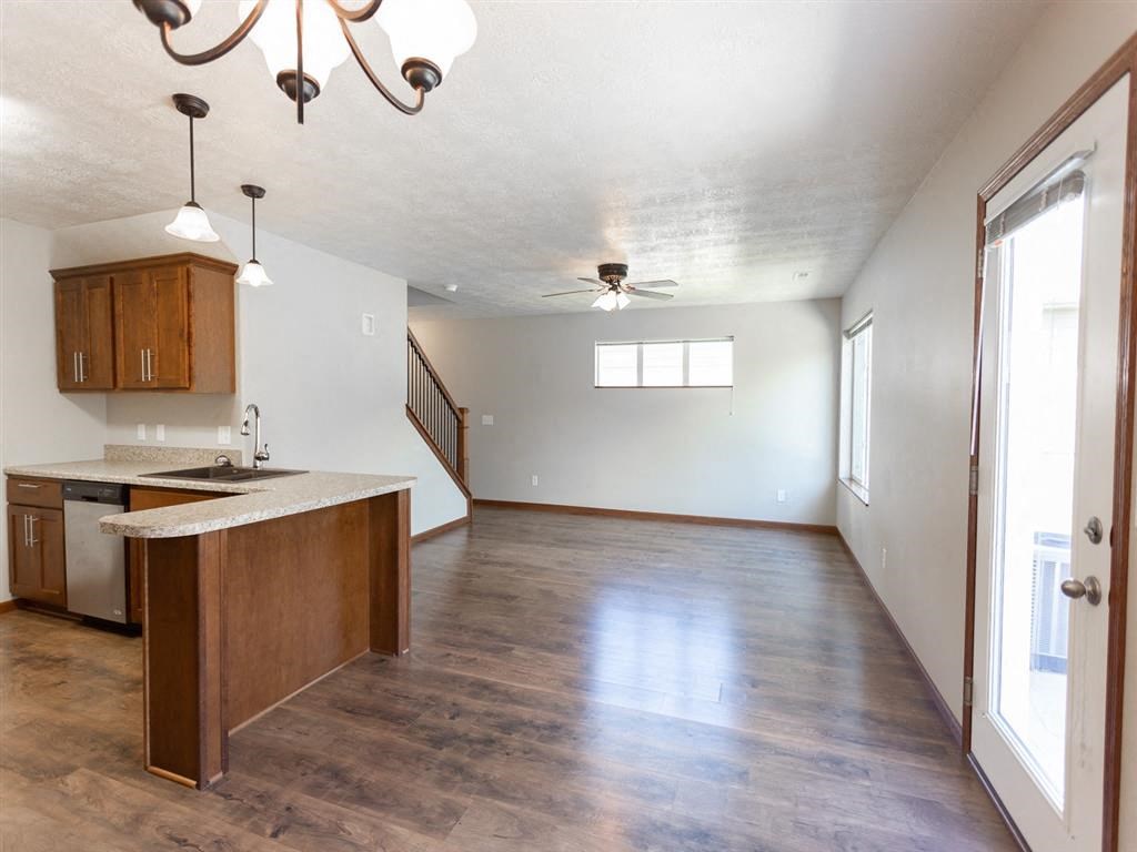 an empty kitchen and living room with wood floors