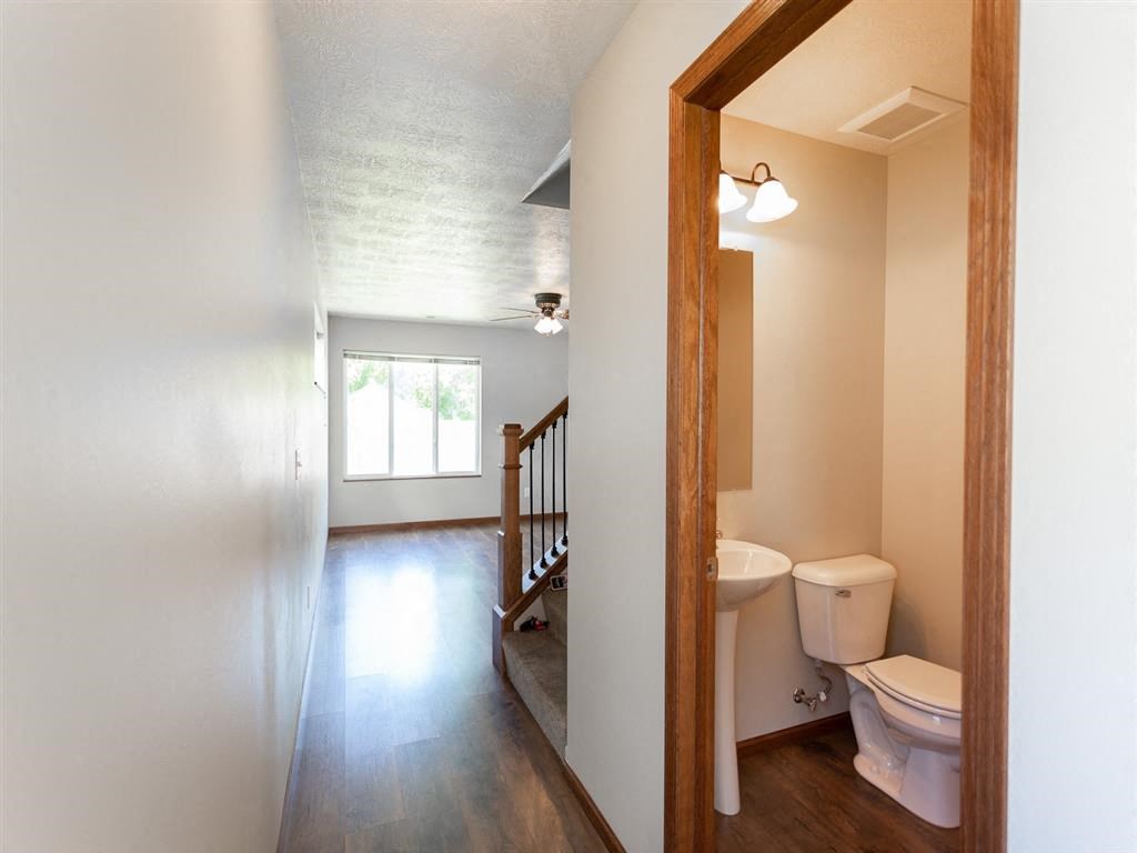 a bathroom with a toilet and a staircase in a house
