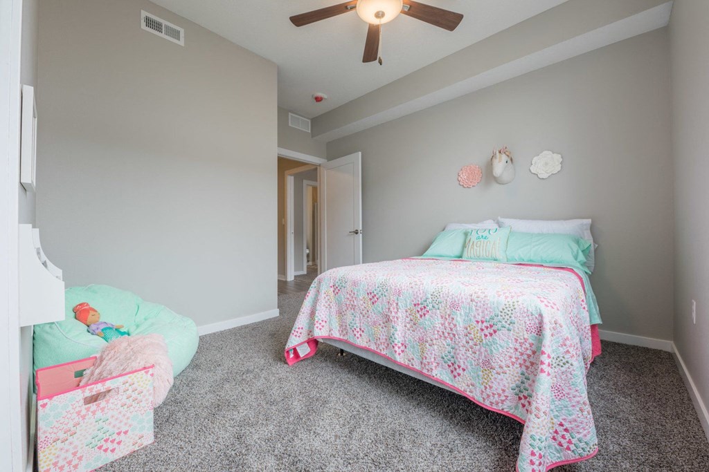 a bedroom with a bed and a ceiling fan