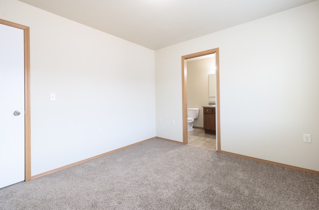 A room with a carpeted floor and a mirror on the wall.