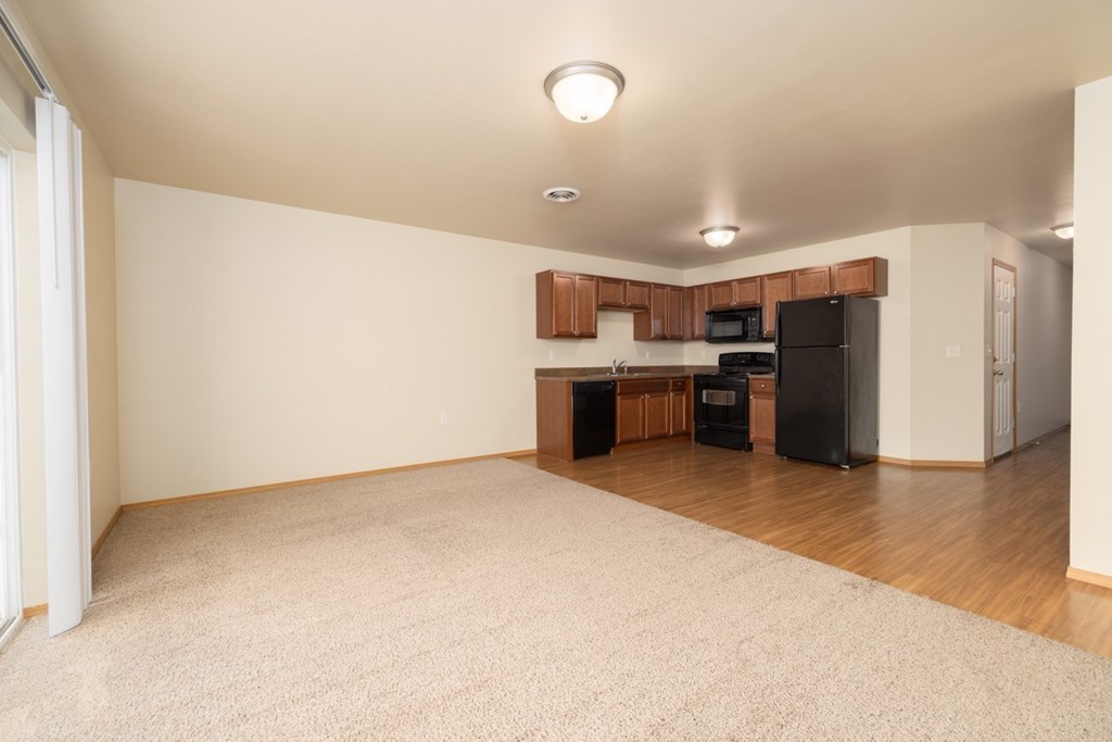 A kitchen area with a black fridge, microwave, and oven.
