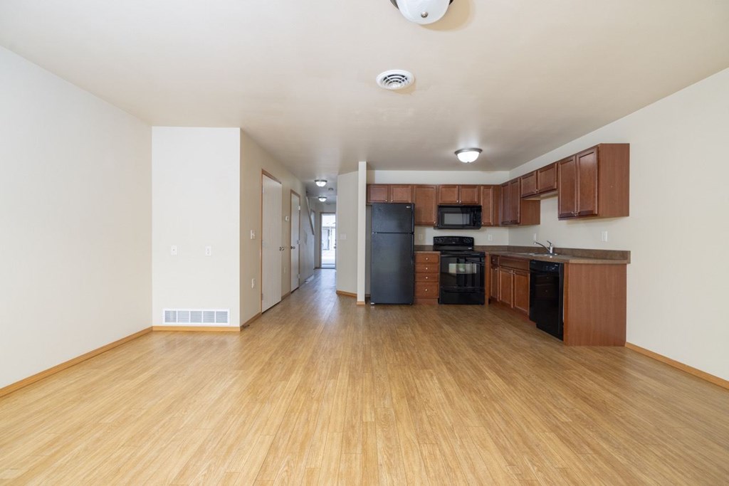 A kitchen with wooden floors and white walls.