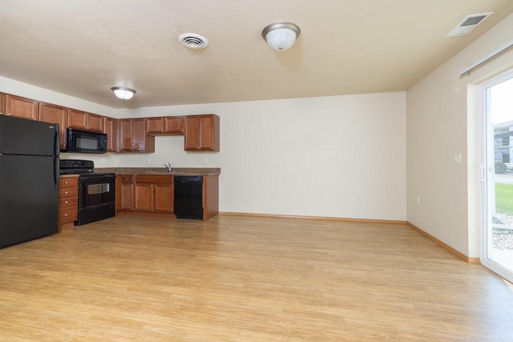 A kitchen with black appliances and wooden cabinets.