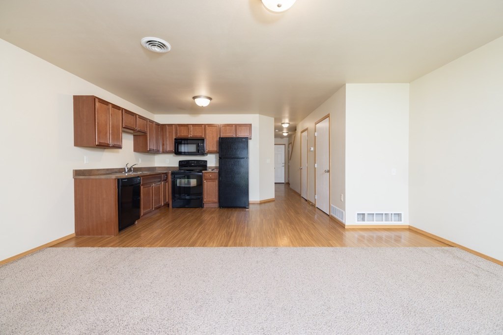 A kitchen with wooden cabinets and appliances.