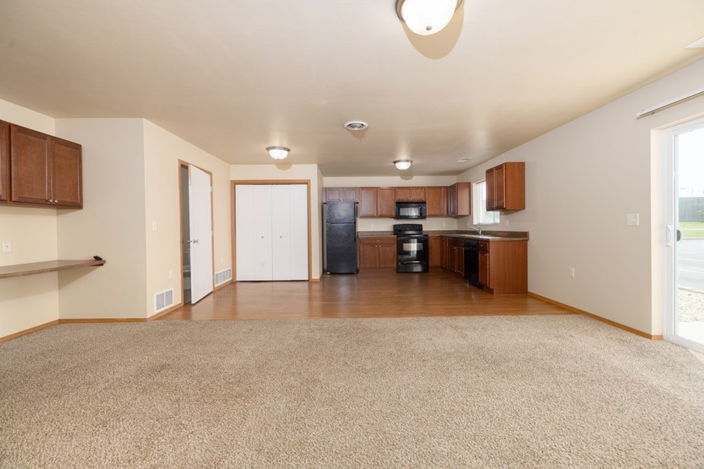 A kitchen area with brown cabinets and a white fridge.