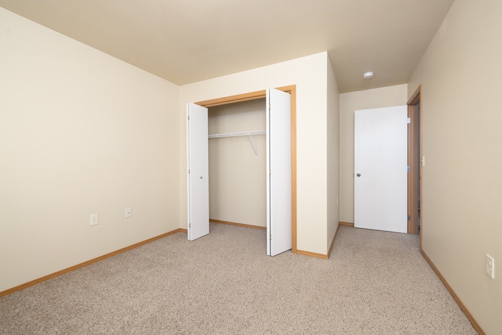 A room with a carpeted floor and a white door.