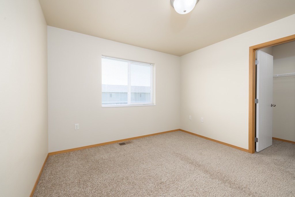 A room with a carpeted floor and a window.