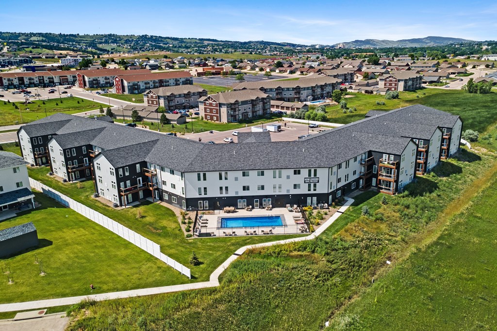A large building with a pool in the middle of a grassy area.