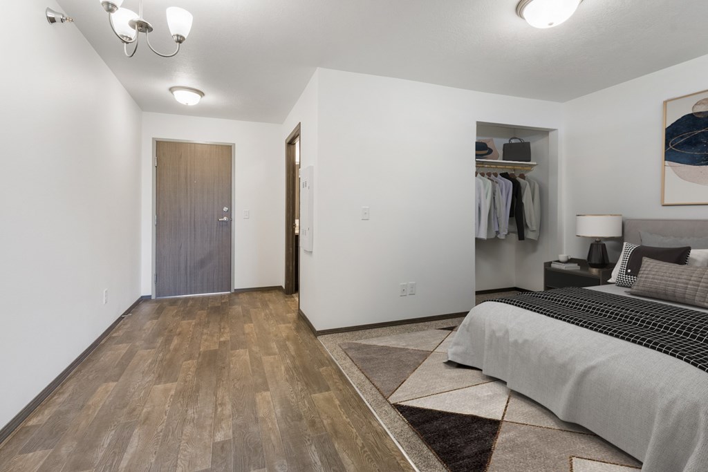 A bedroom with a bed, a wardrobe, and a painting on the wall.