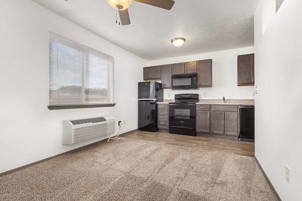 A kitchen with a black stove top oven and microwave.