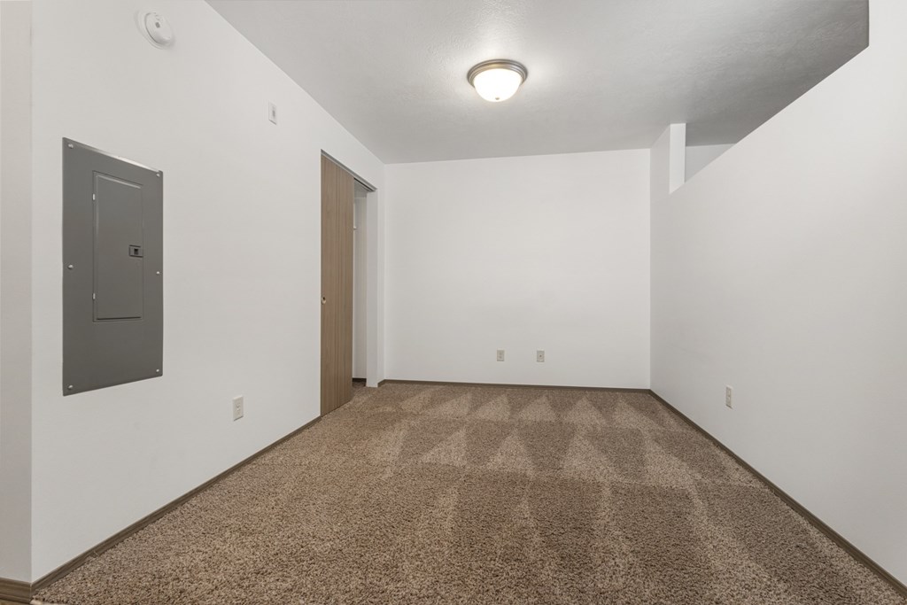 A room with a carpeted floor and a door.
