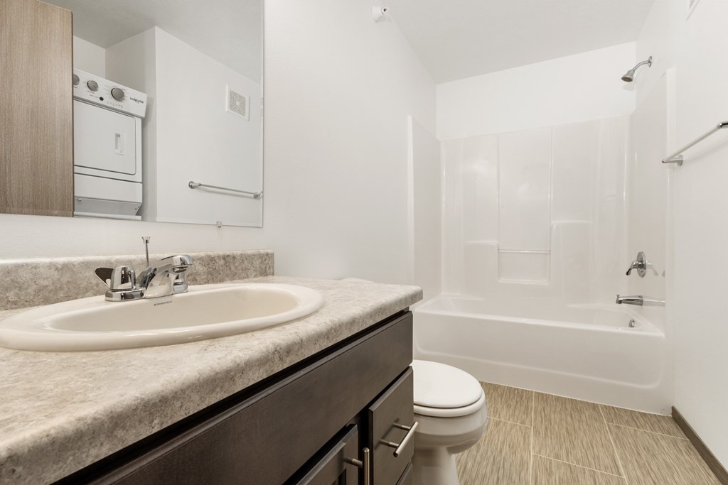 A bathroom with a sink, toilet, and bathtub.
