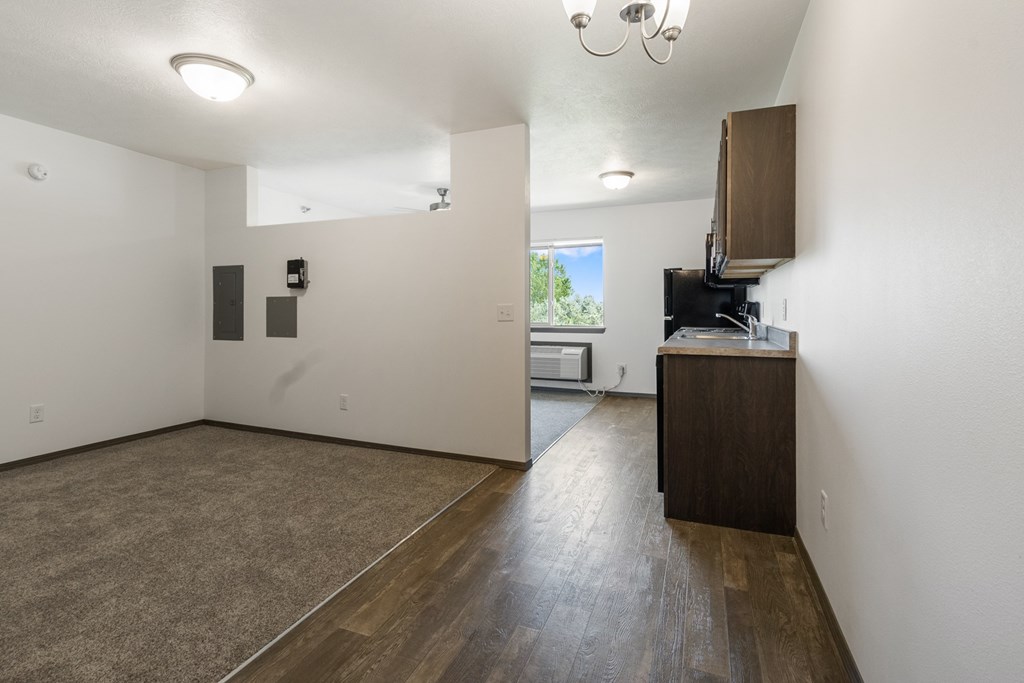 A room with a brown floor and white walls.
