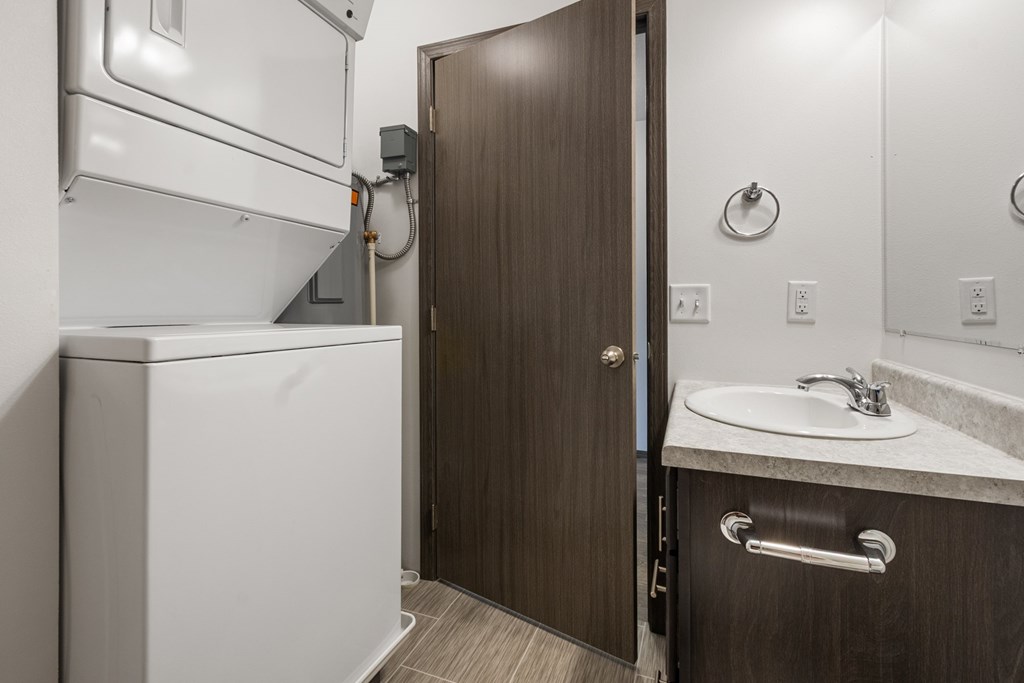 A bathroom with a white toilet and a brown door.