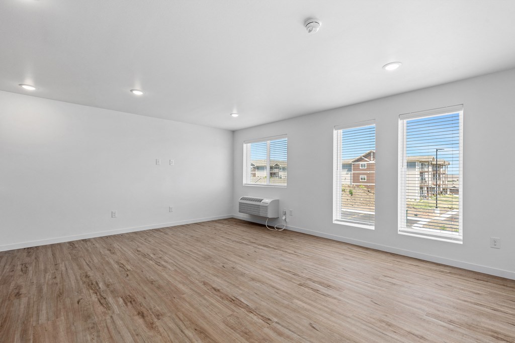 an empty living room with white walls and wood floors