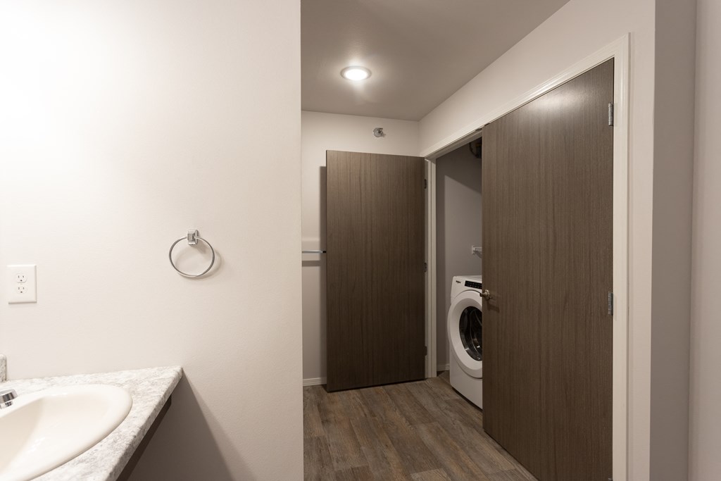 a bathroom with a washer and dryer and a sink and a closet