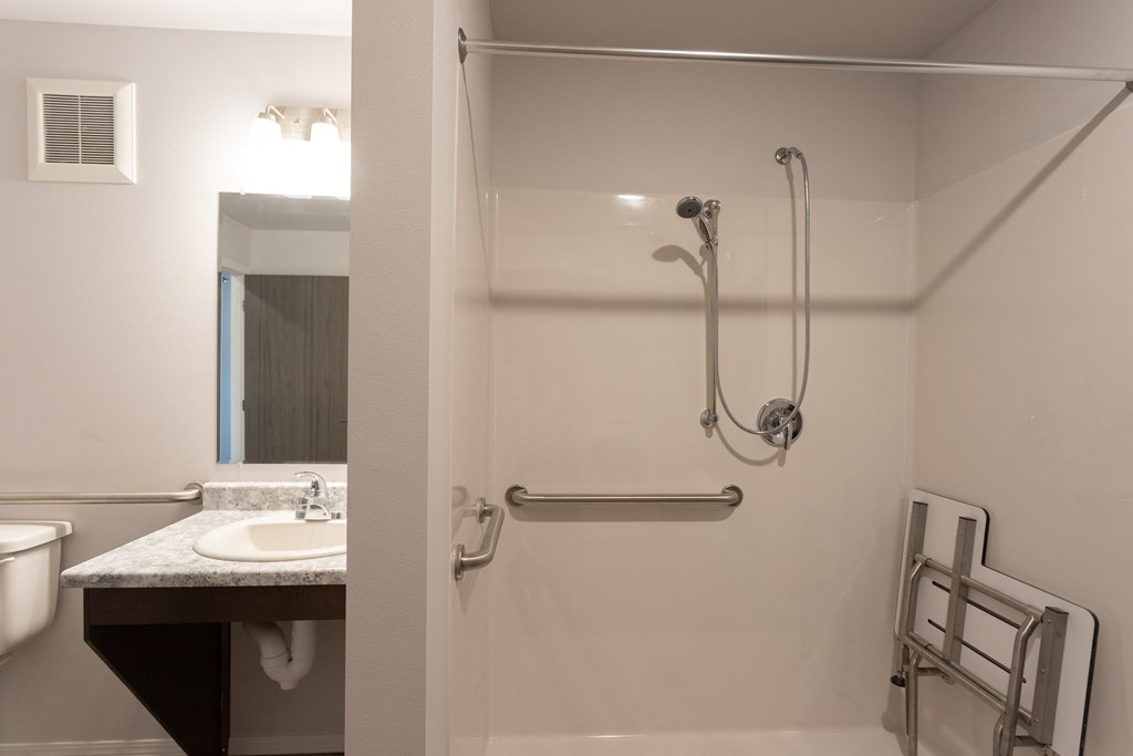 a bathroom with a shower and a sink and a toilet