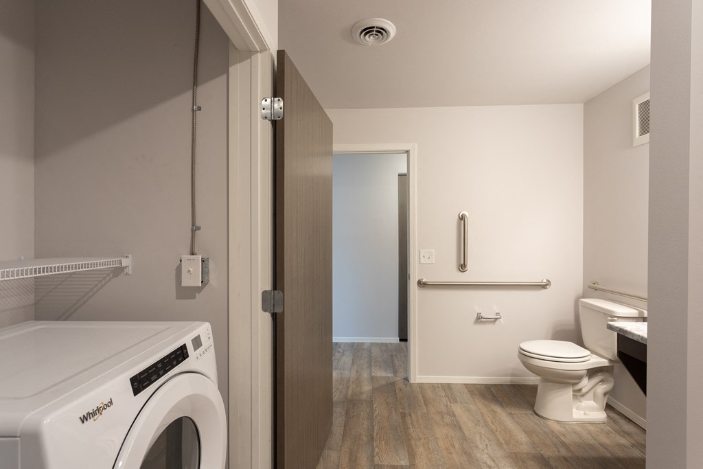 a bathroom with a washer dryer and a toilet in it