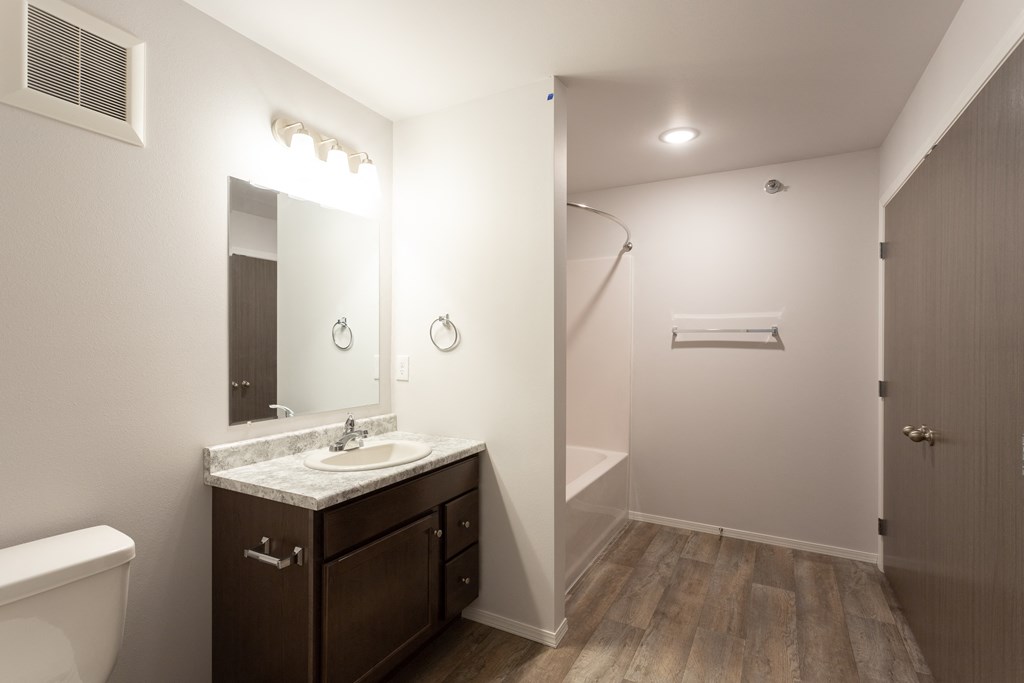 a bathroom with a large mirror and a toilet and a sink