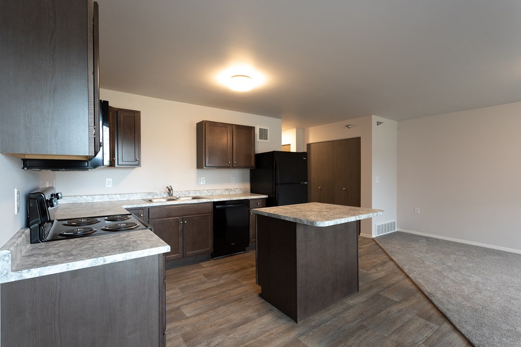a kitchen with an island and a stove and a refrigerator