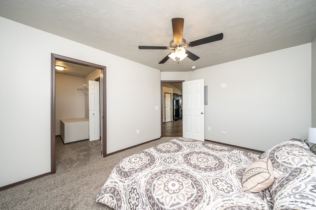 a bedroom with a ceiling fan and a bed