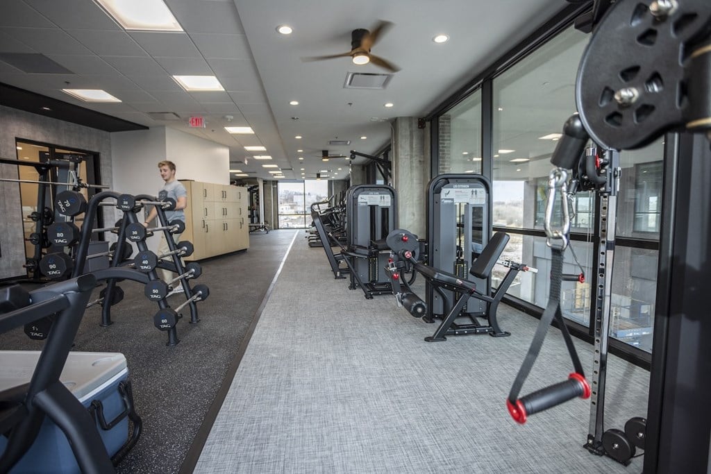 a man standing in a gym with weights and other exercise equipment