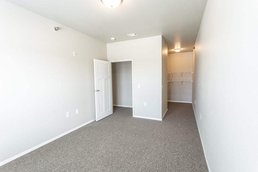 an empty room with white walls and carpet and a white door