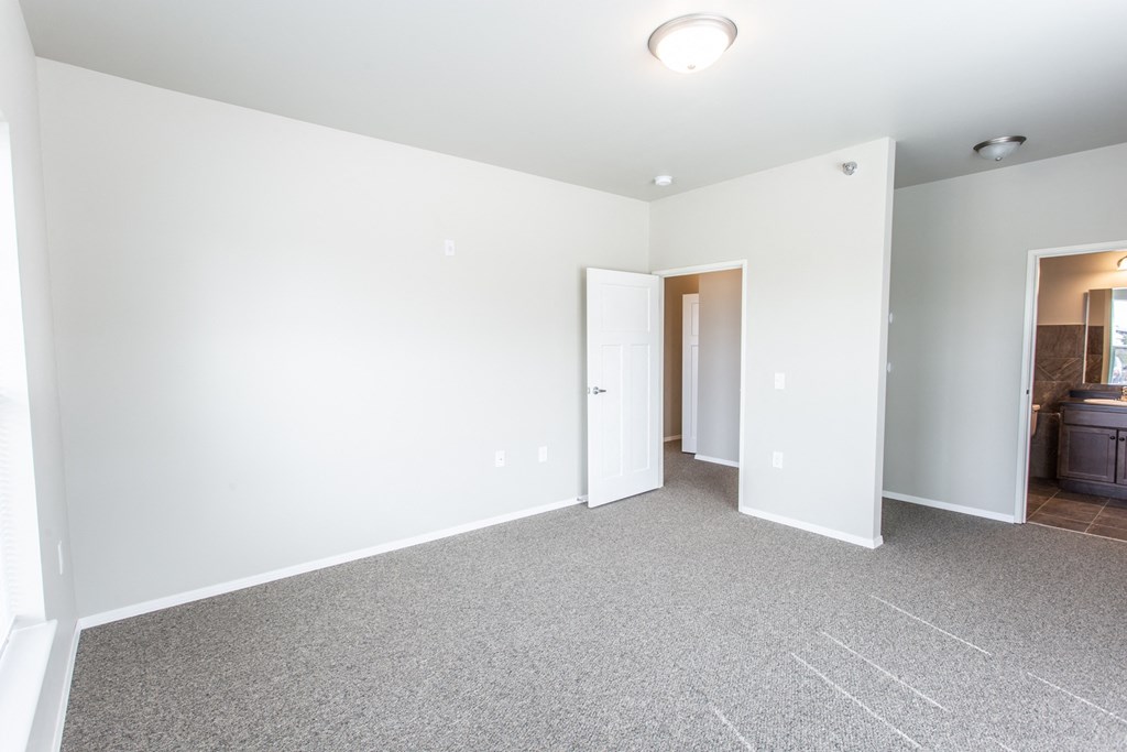an empty living room with white walls and carpet