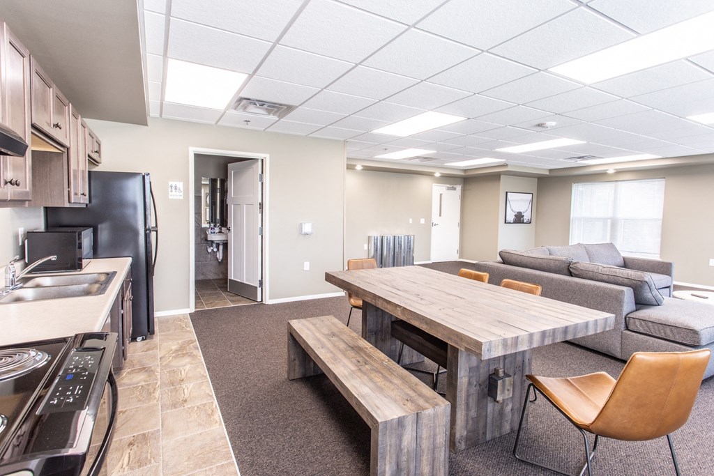 a kitchen and living room with a wooden dining table