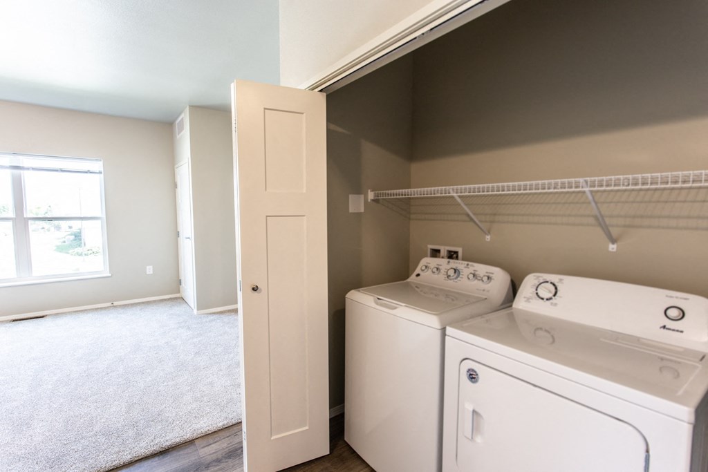an empty room with a washer and dryer in it and a laundry room