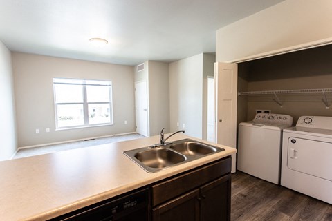 a kitchen with a sink and a washer and dryer and a window