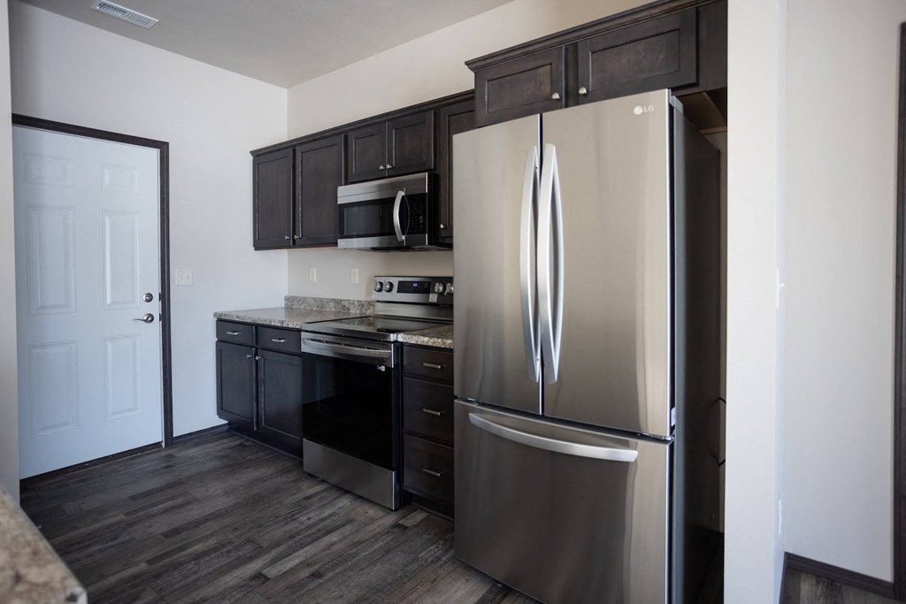a kitchen with stainless steel appliances and black cabinets