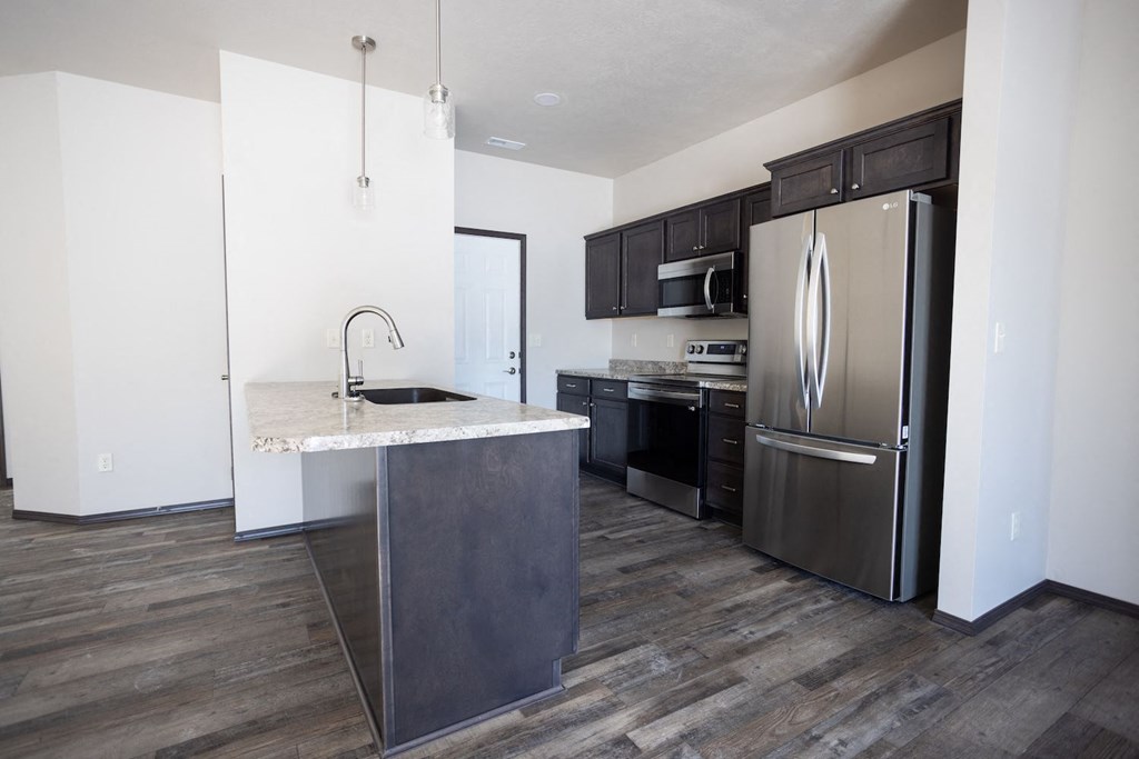 a kitchen with stainless steel appliances and a marble counter top
