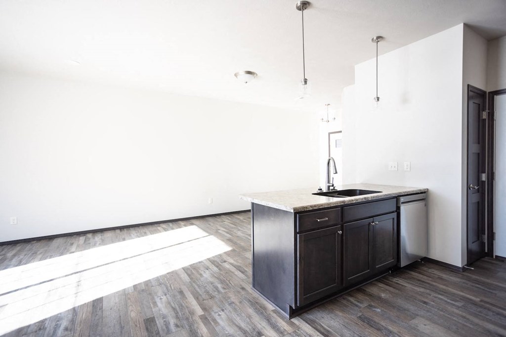 an empty room with a kitchen and a sink