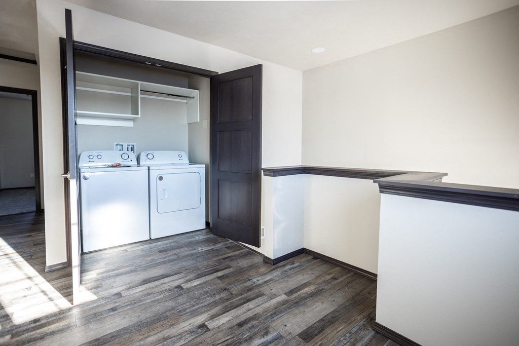 a laundry room with a washer and dryer and a door to a kitchen