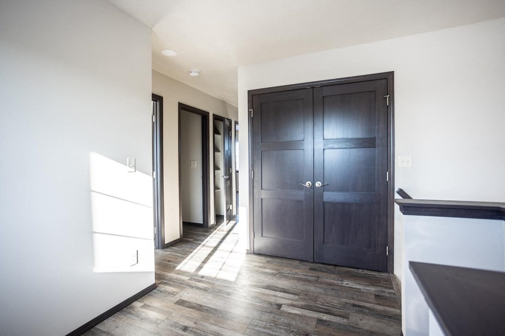 a large hallway with wooden floors and a black door