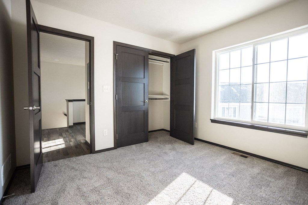 an empty room with three doors and a window