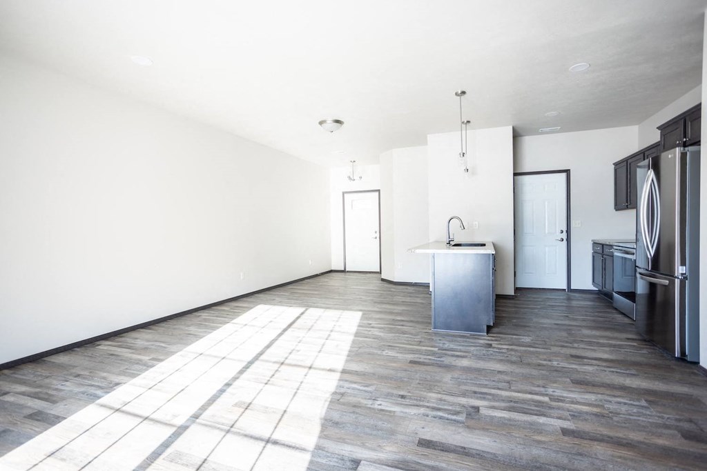 an empty kitchen with white walls and a stainless steel island