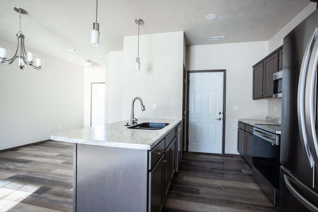 a kitchen with stainless steel appliances and a marble counter top