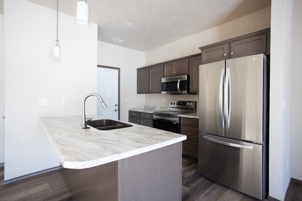 a kitchen with stainless steel appliances and a marble counter top
