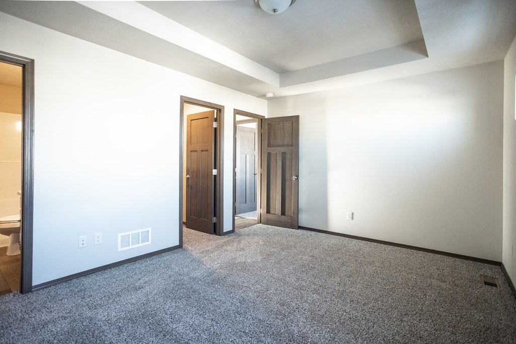 an empty living room with white walls and carpet