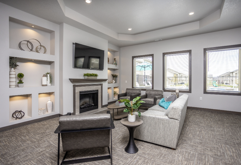 Spacious community room with fireplace, kitchen, and lounge seating.