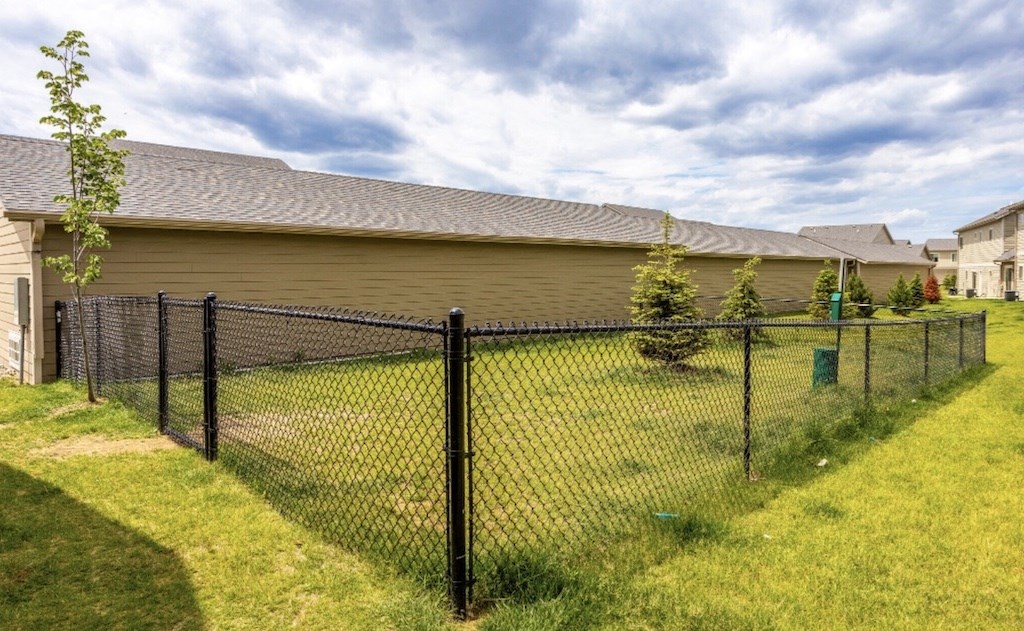 Fenced dog park with agility equipment.