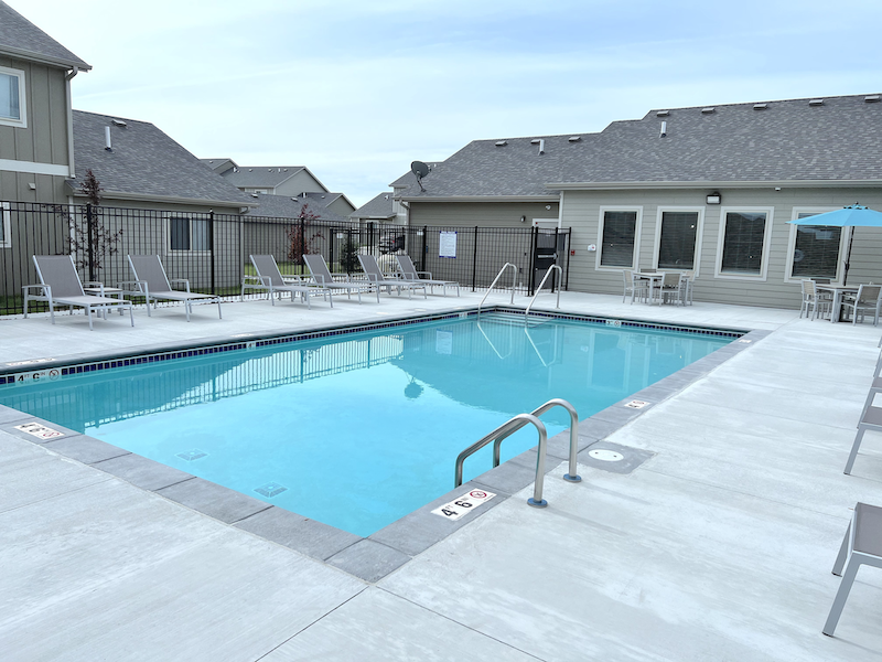 Sparkling blue pool surrounded by lounge chairs.