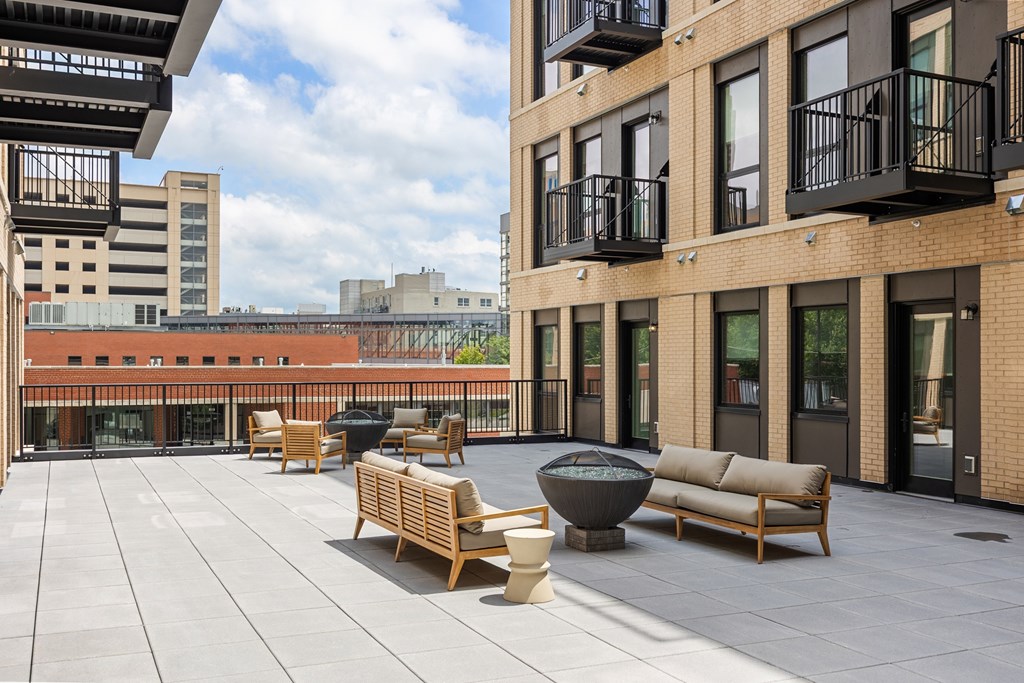 A patio with wooden furniture and a fire pit.