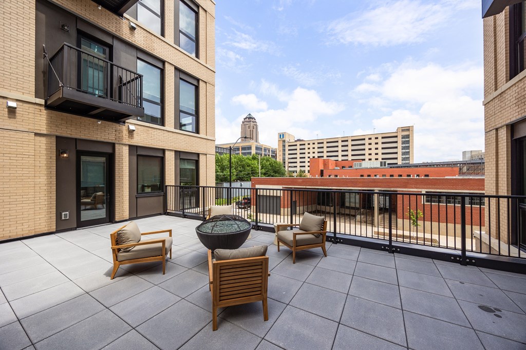 A patio with a table and chairs is surrounded by buildings.