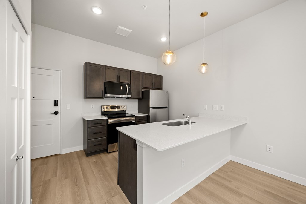 A kitchen with a white counter top and brown cabinets.