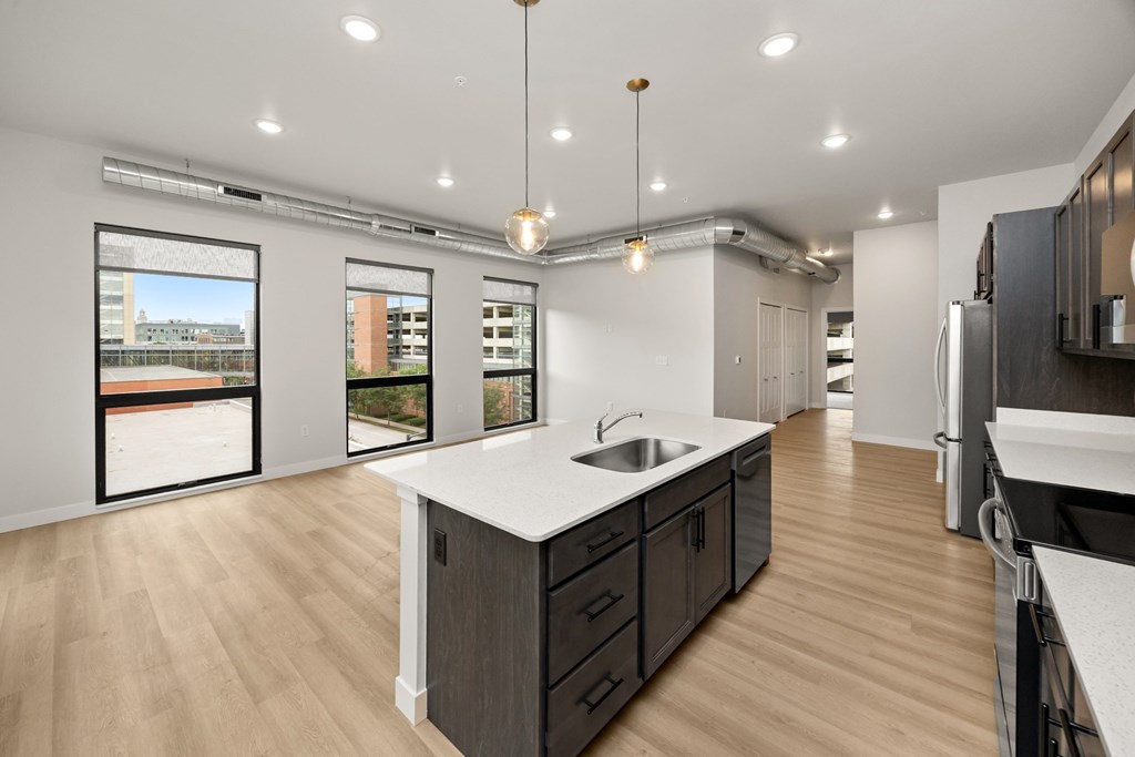 A modern kitchen with a large island and wooden floors.