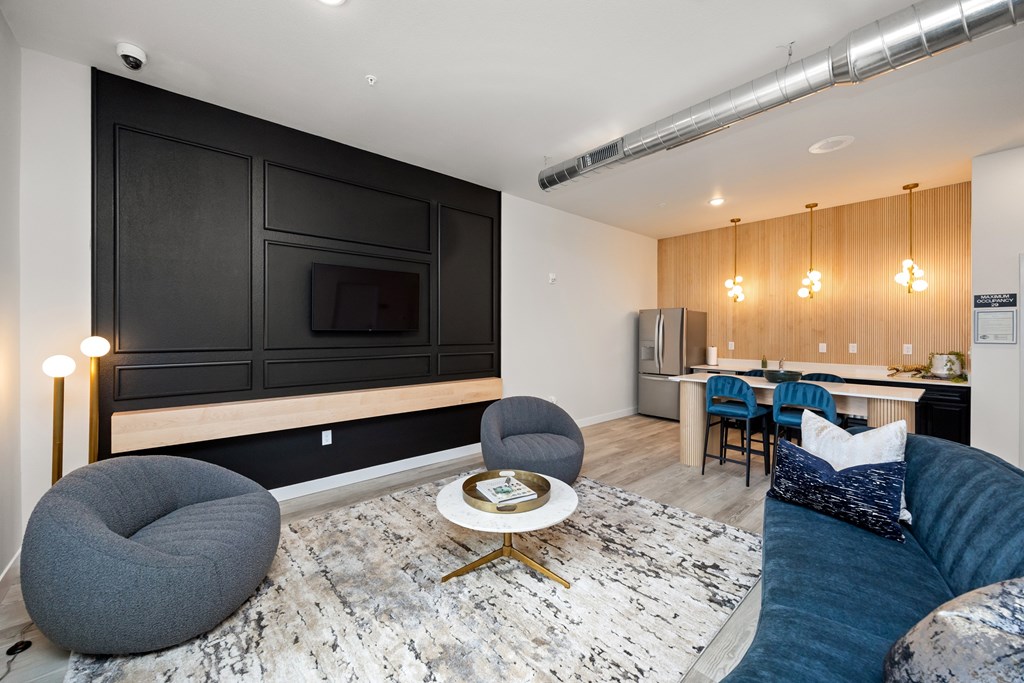 A modern living room with a grey bean bag chair and a round white coffee table.