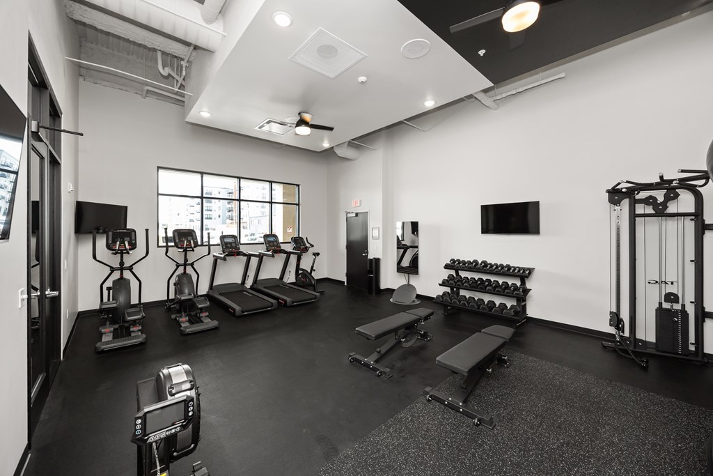 A black and white photo of a gym with various exercise equipment.